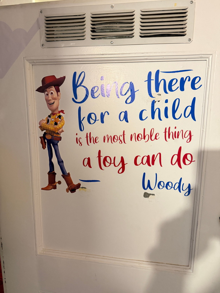 Inspirational Woody quote on wall about being there for children.